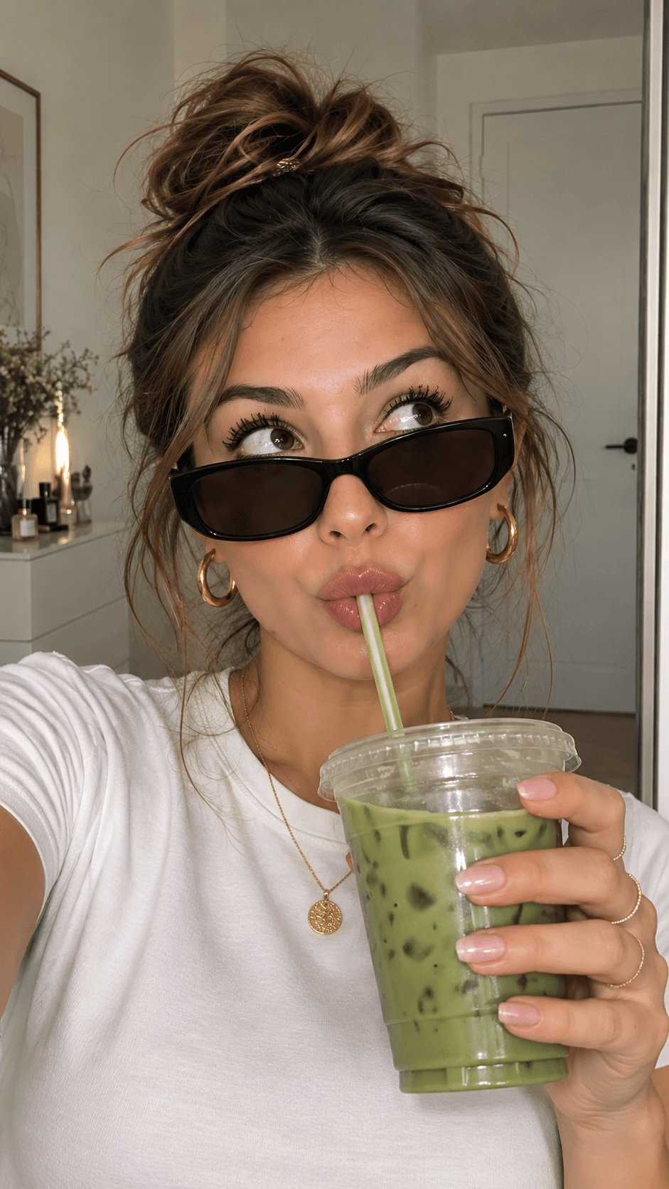 Mia mit Sonnenbrille trinkt einen Iced Matcha